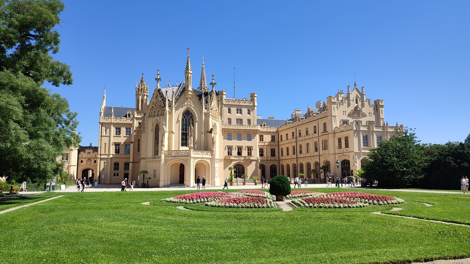 Schloss Lednice mit neugotischer Fassade, Blumenbeeten und Rasen