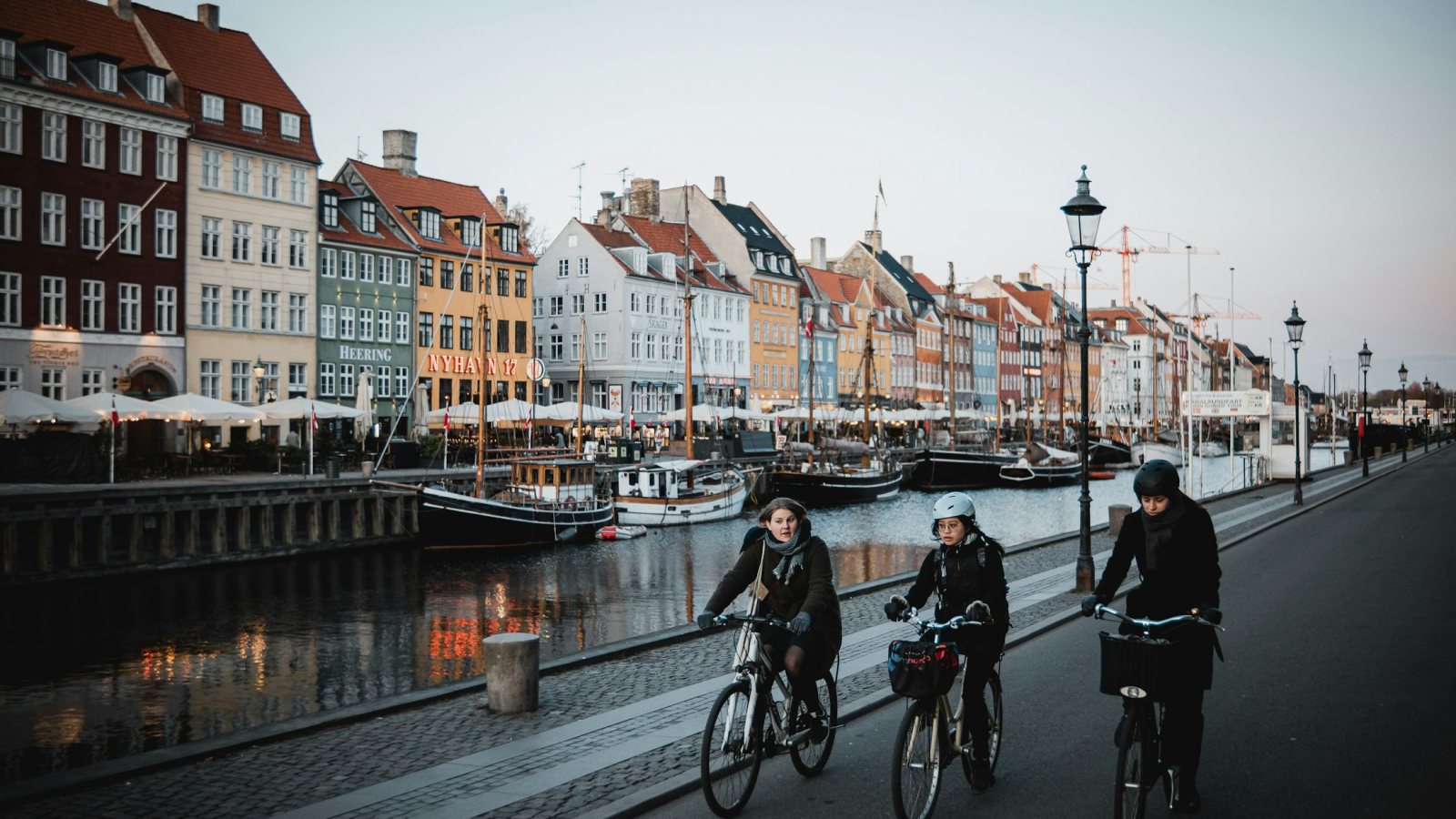 Radfahrer am Nyhavn in Kopenhagen mit Kanal und bunten Häusern
