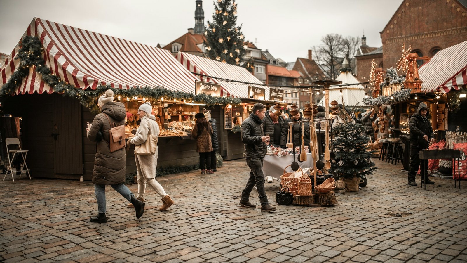 Weihnachtsmarkt mit beleuchteten Ständen und Besuchern in einer europäischen Altstadt